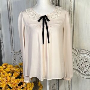 Elegant Blush Blouse with Lace Collar Detail and Black Bow Tie